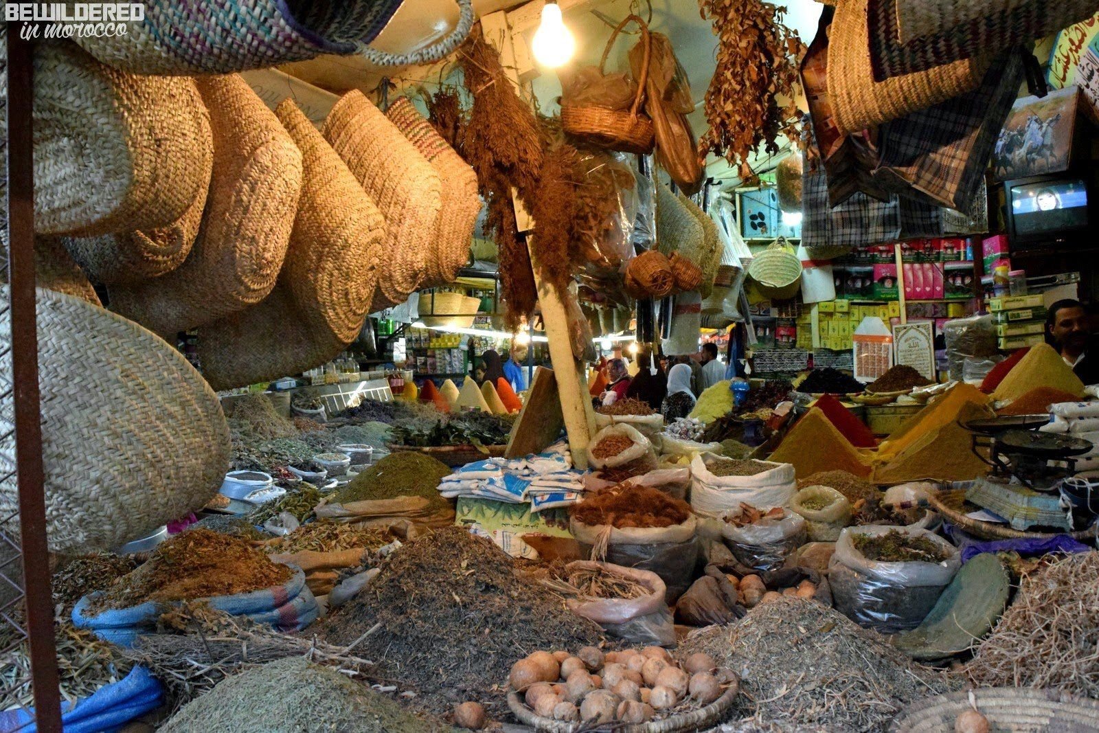 Spices, dried herbs, and woven baskets displayed at a souk stall in Casablanca's Habous Quarter