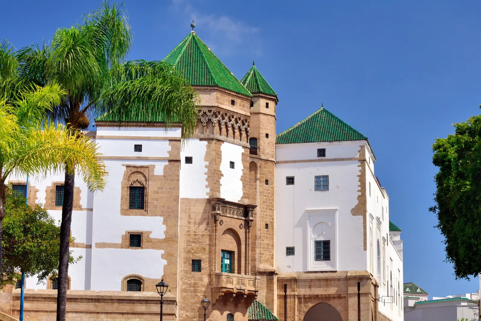 Green-tiled Moroccan building with ornate towers in Casablanca's Habous Quarter