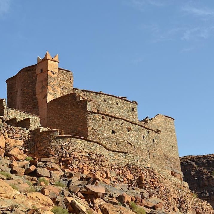 A fortified granary carved into the mountainside, used as part of the Igoudar banking system in Morocco.