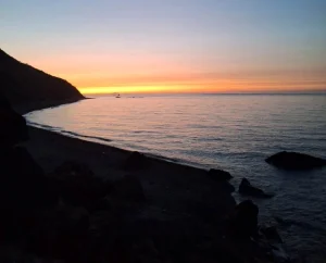 Discover Jnan Nich Beach, a hidden black sand paradise in northern Morocco. Crystal clear waters, dramatic cliffs, and authentic Berber culture await.
