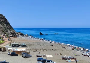 Discover Jnan Nich Beach, a hidden black sand paradise in northern Morocco. Crystal clear waters, dramatic cliffs, and authentic Berber culture await.